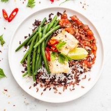 lunch in a vegetarian box diet with fish - redfish with pineapple salsa with chili, colored jasmine rice, blanched green beans